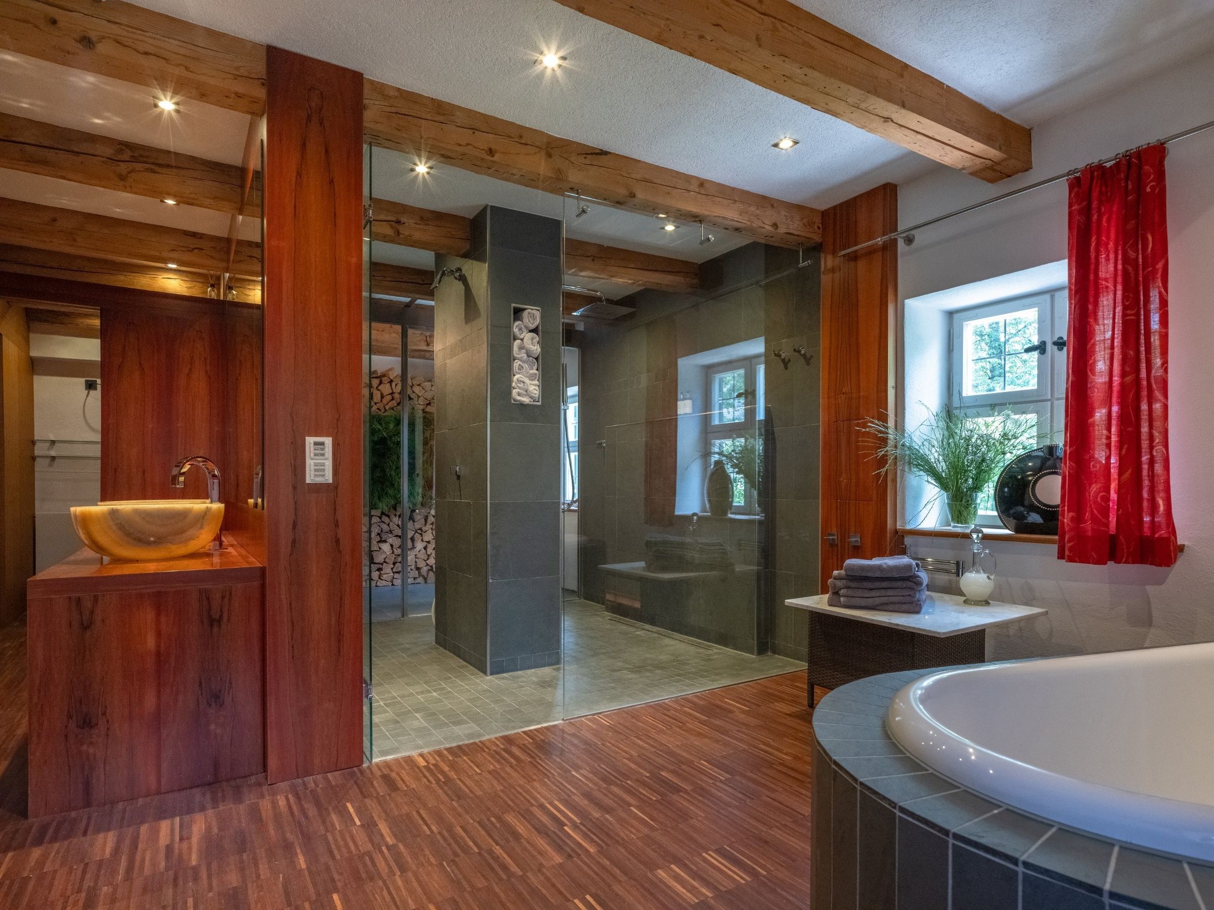 Bad im 1. Obergeschoss: Badewanne, begehbare Glasdusche und Onyx-Waschschale unter alten Deckenbalken