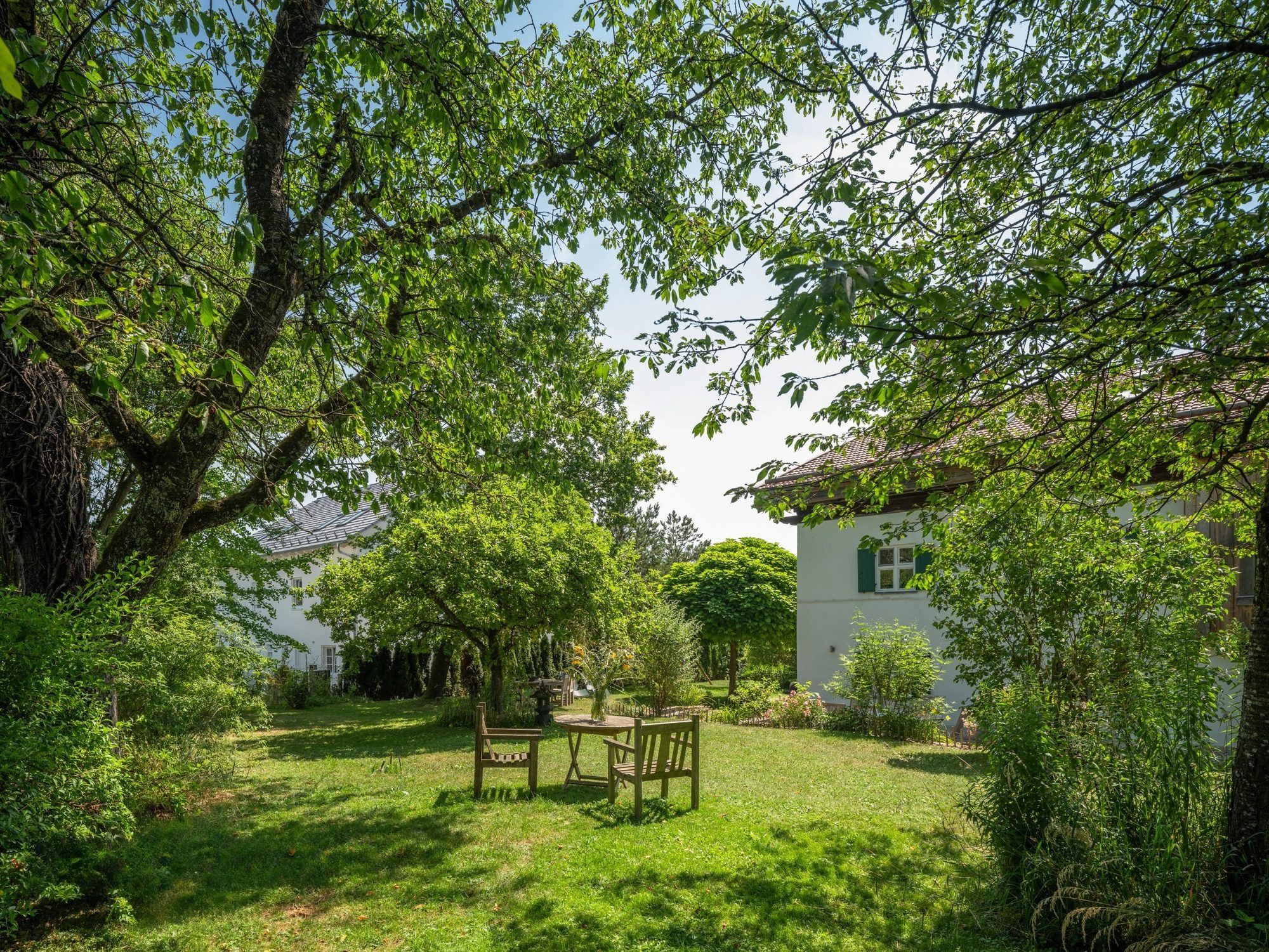Bauerngarten mit alten Bäumen, Wiese und Gartenmöbeln